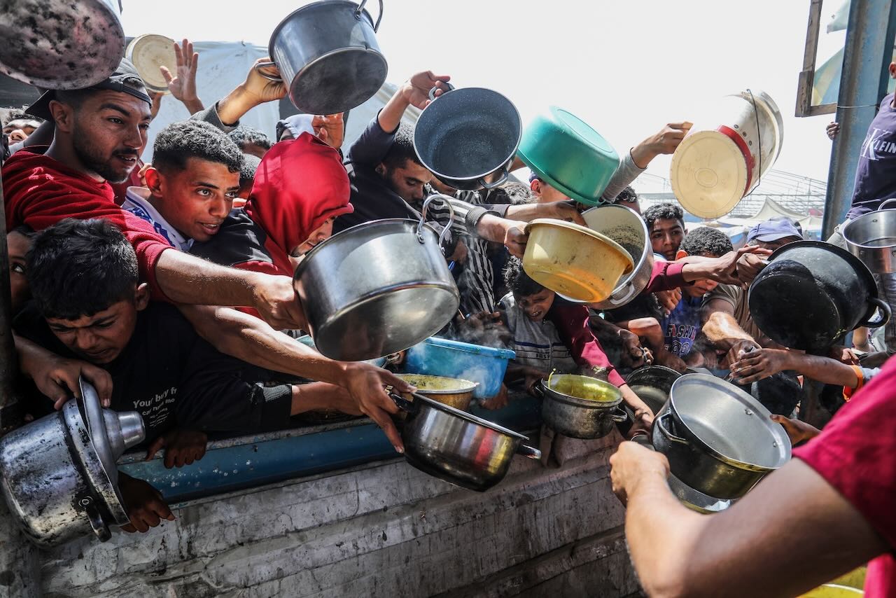 Le 3 mai 2025, des Palestiniens déplacés à Al-Mawasi, Khan Yunis, dans le sud de la bande de Gaza, tentent de recevoir de la nourriture.